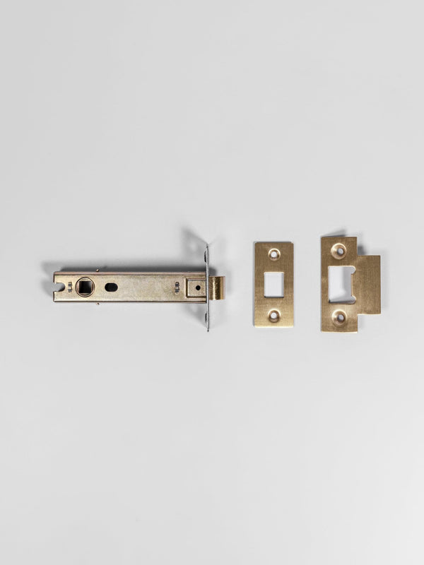 A top view of a natural brass colored door latch
