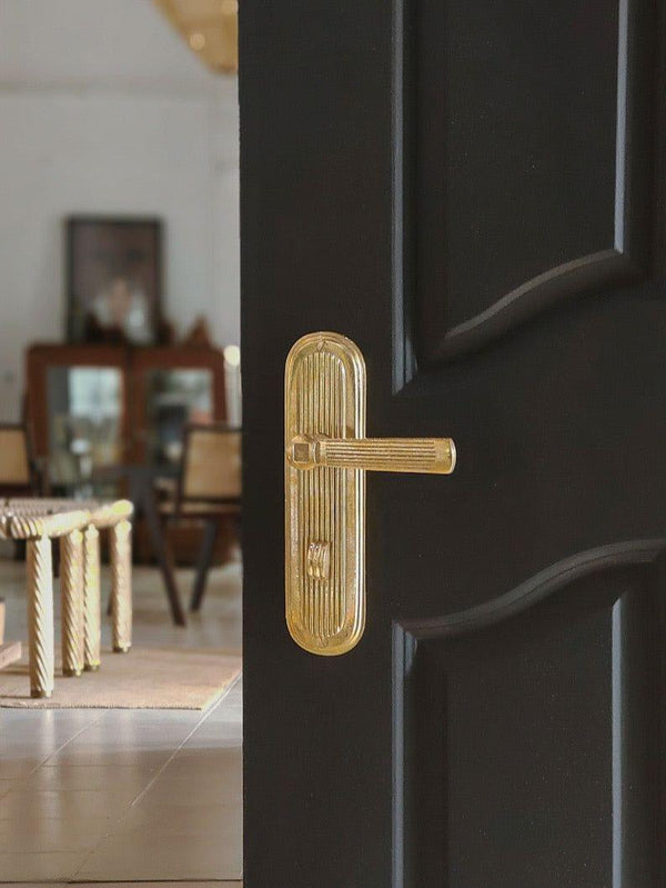 A right side view of a natural brass finish privacy door lever set